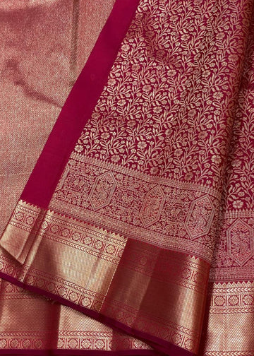 Close-up of a maroon and gold saree with intricate patterns