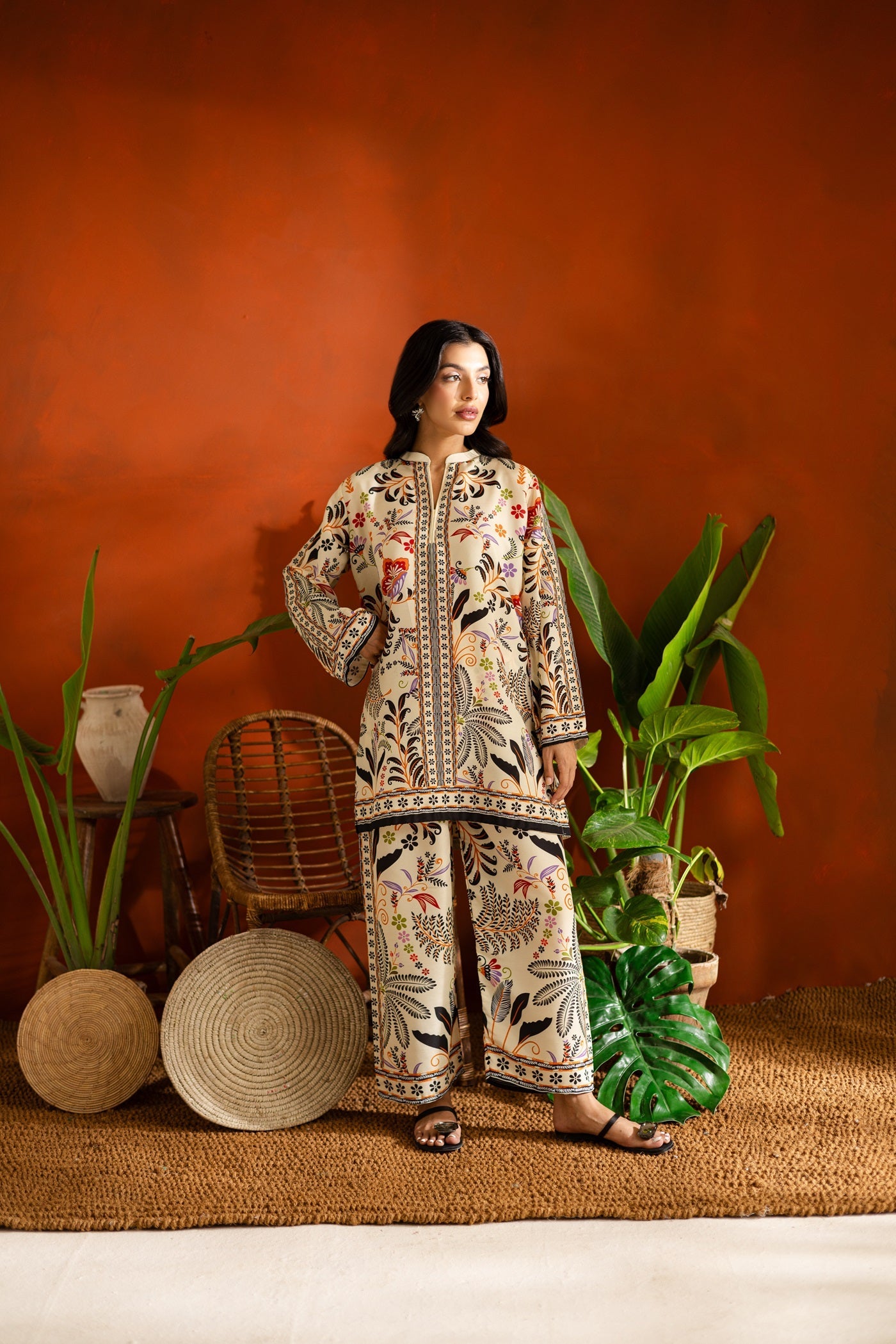 Woman in a Garden patterned Printed outfit standing in a room with plants and rustic decor.