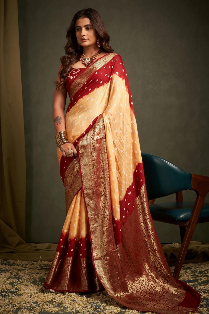 Woman wearing a traditional maroon and beige saree with jewelry against a neutral background