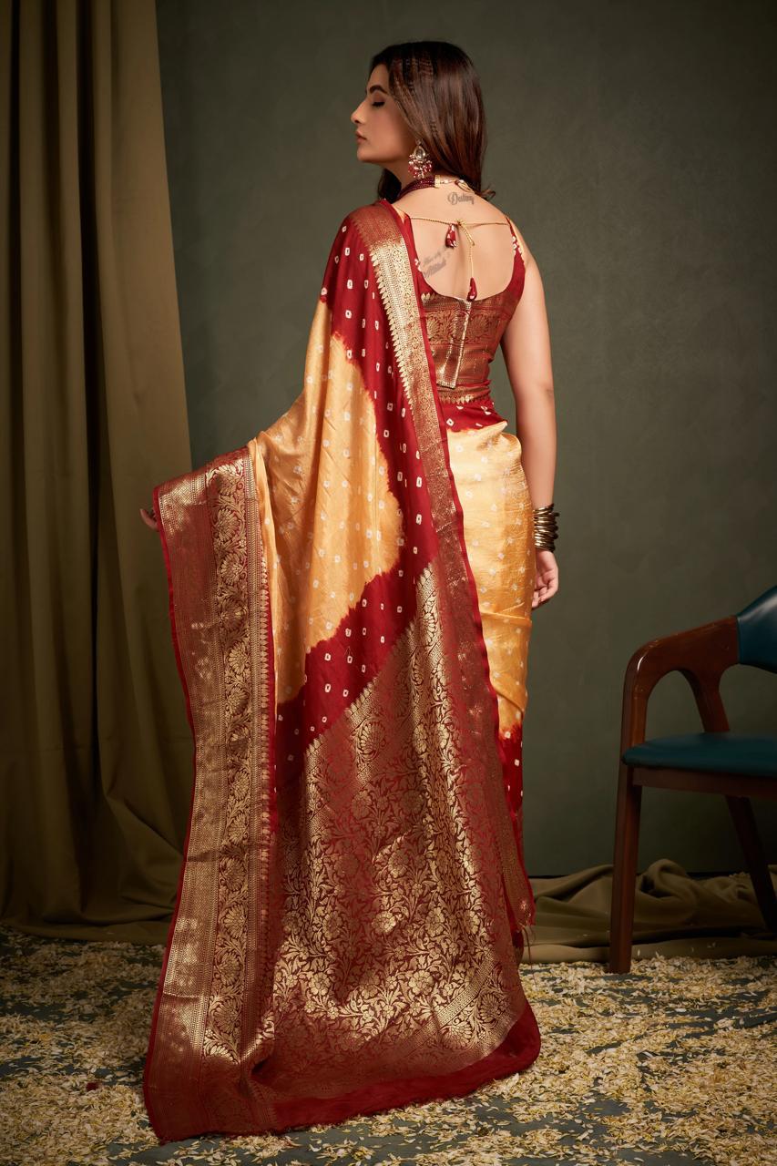 Woman wearing a traditional saree with a red and gold pattern, standing against a plain background.