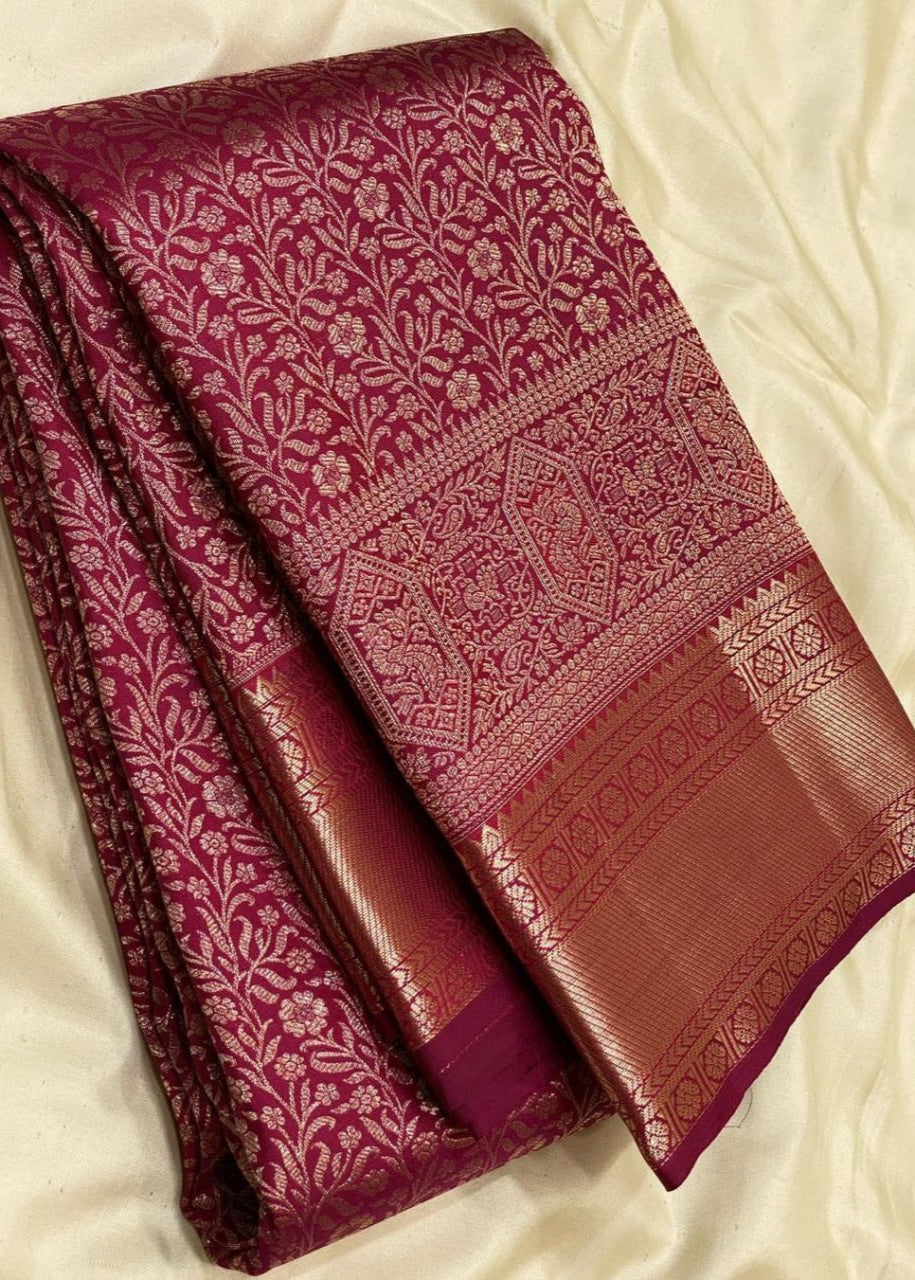 Close-up of a maroon and gold saree with intricate patterns

