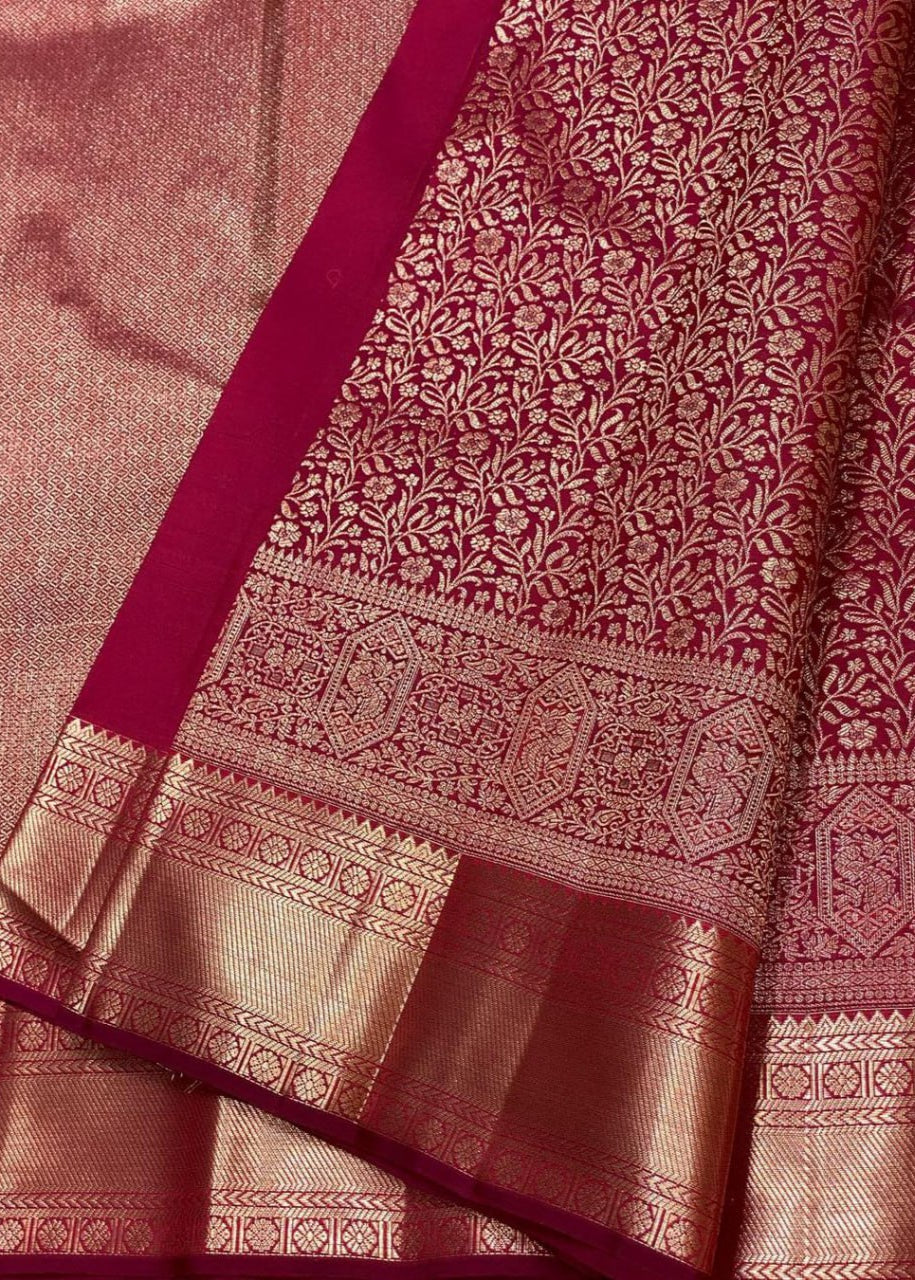Close-up of a maroon and gold saree with intricate patterns

