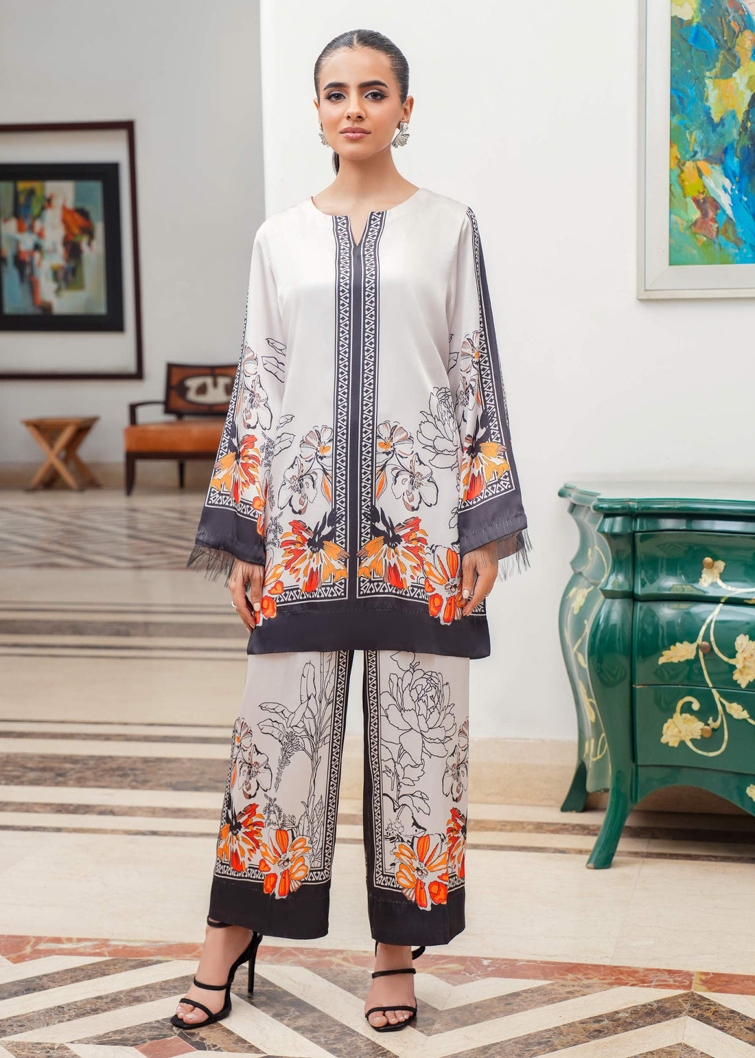 Woman in a stylish outfit with floral patterns in an elegant room.